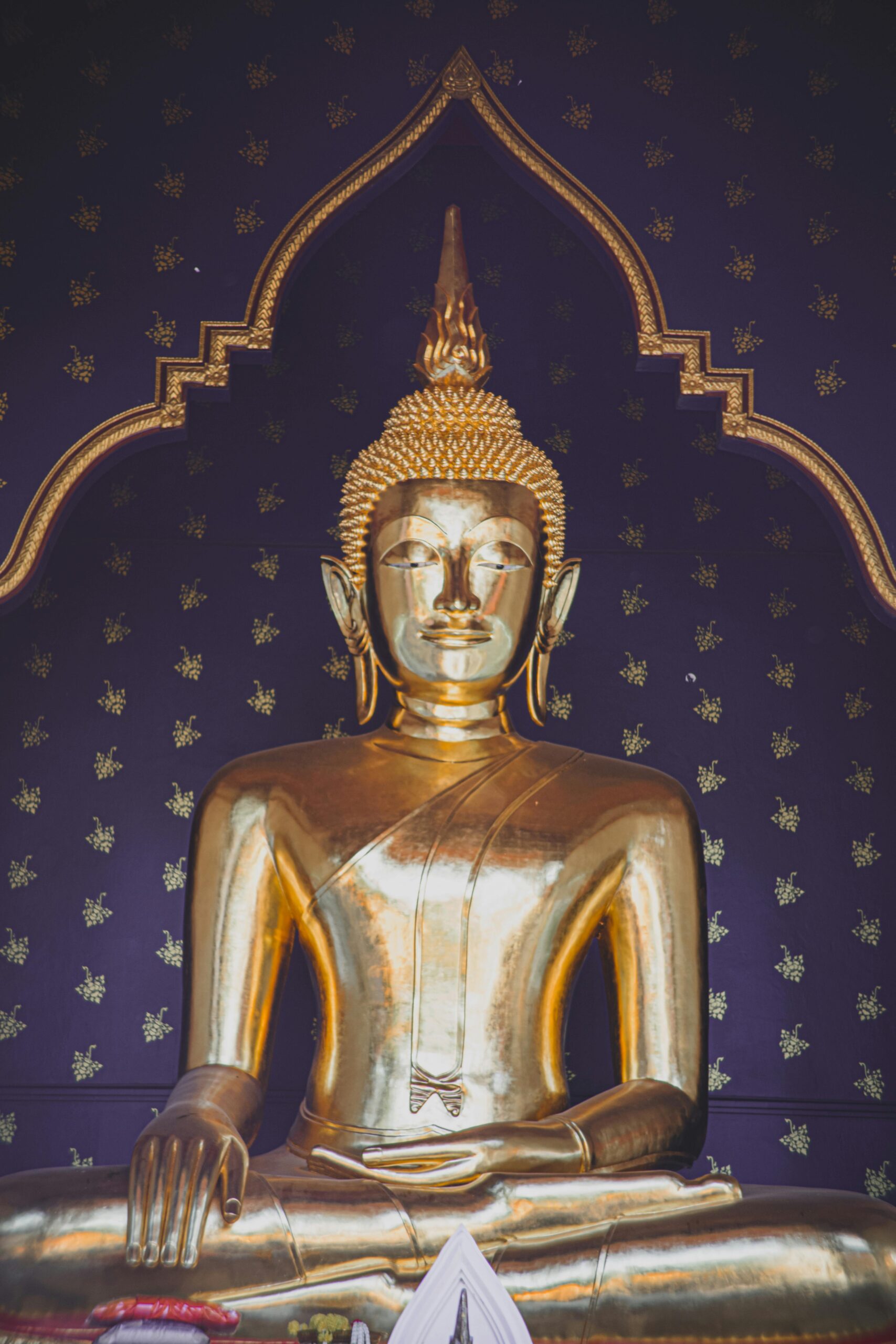 Stunning golden Buddha statue inside a traditional temple in Thailand, highlighting cultural spirituality.