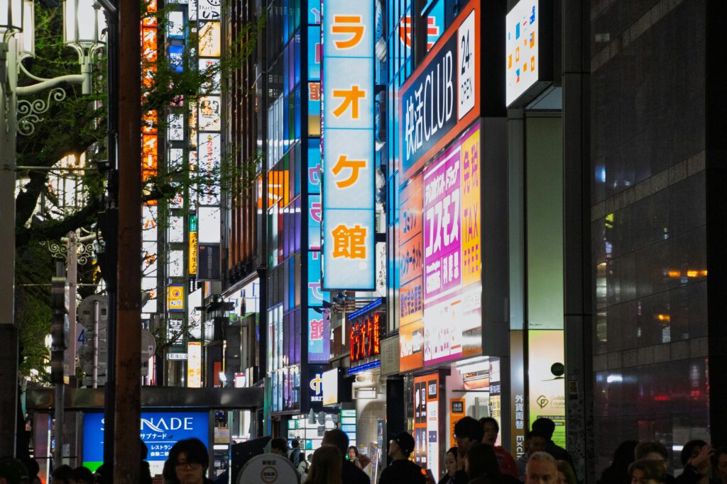 A colorful nighttime scene of Tokyo's lively streets with bright neon signs and a bustling crowd.
