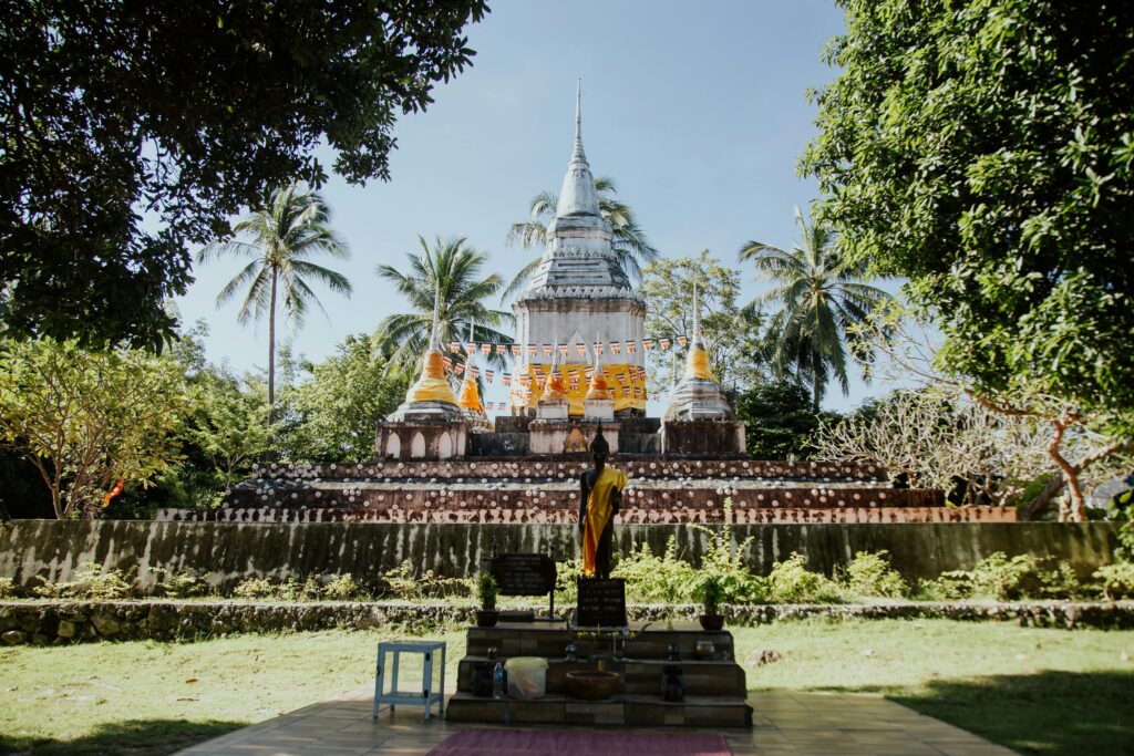Stunning view of Wat Thai Sarnath Temple surrounded by tropical trees, ideal for travel and cultural exploration.